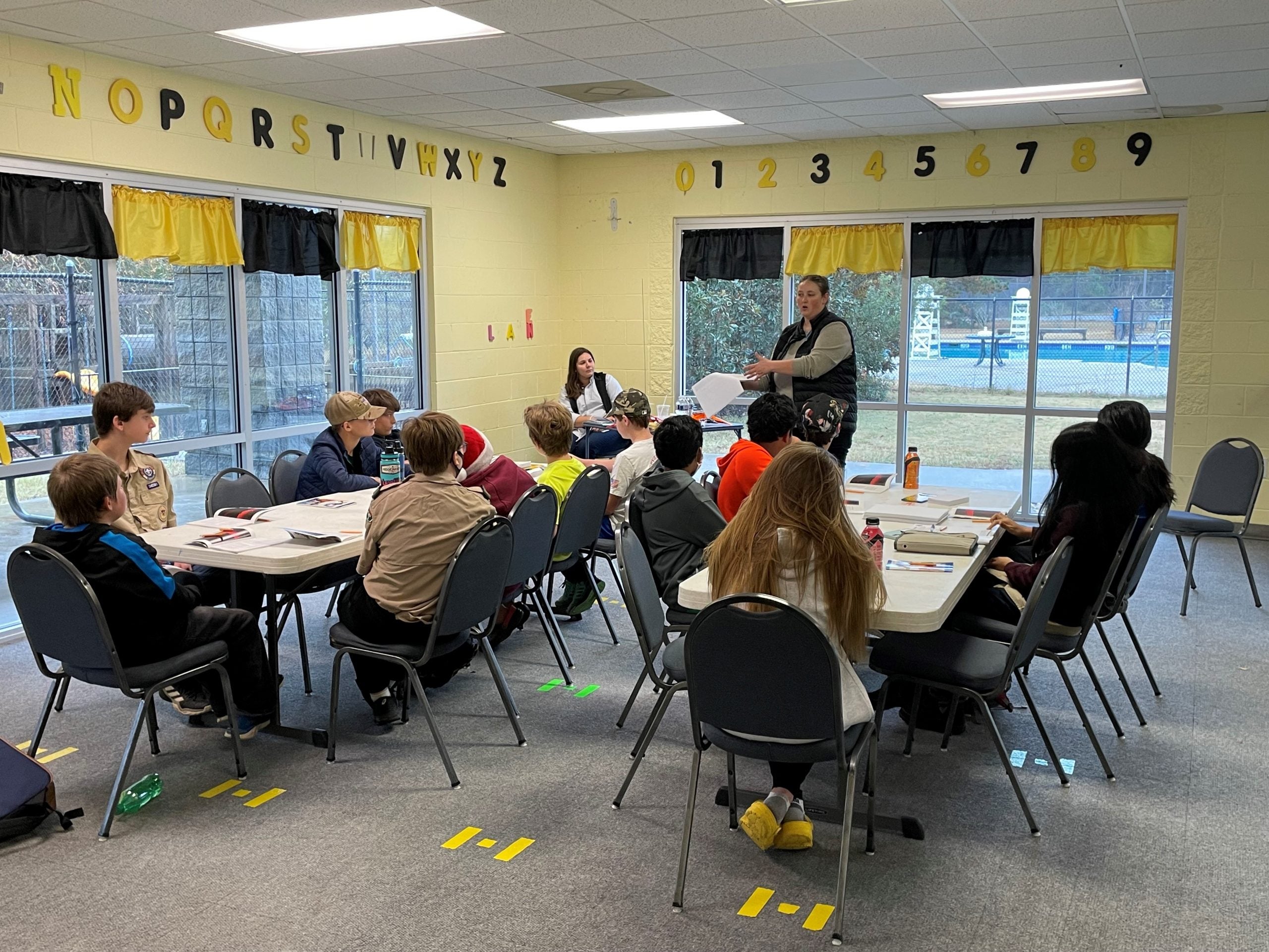 From far left, Bechtel Corp engineers Kate Smith and Samantha Merry teach lessons in rocket science to GCC Scouts looking to earn their Space Exploration Badge. Staff photo by Skyler Q. Andrews.