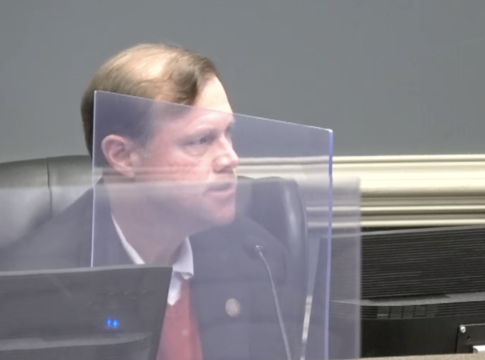 Charlie Walker Jr., elected president of the Richmond County Board of Education, speaks from the other side of a partition Saturday.