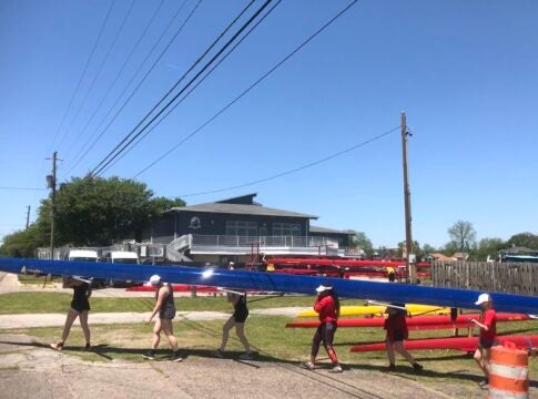 A visiting rowing club transports a scull outside the city-owned Boathouse last April.