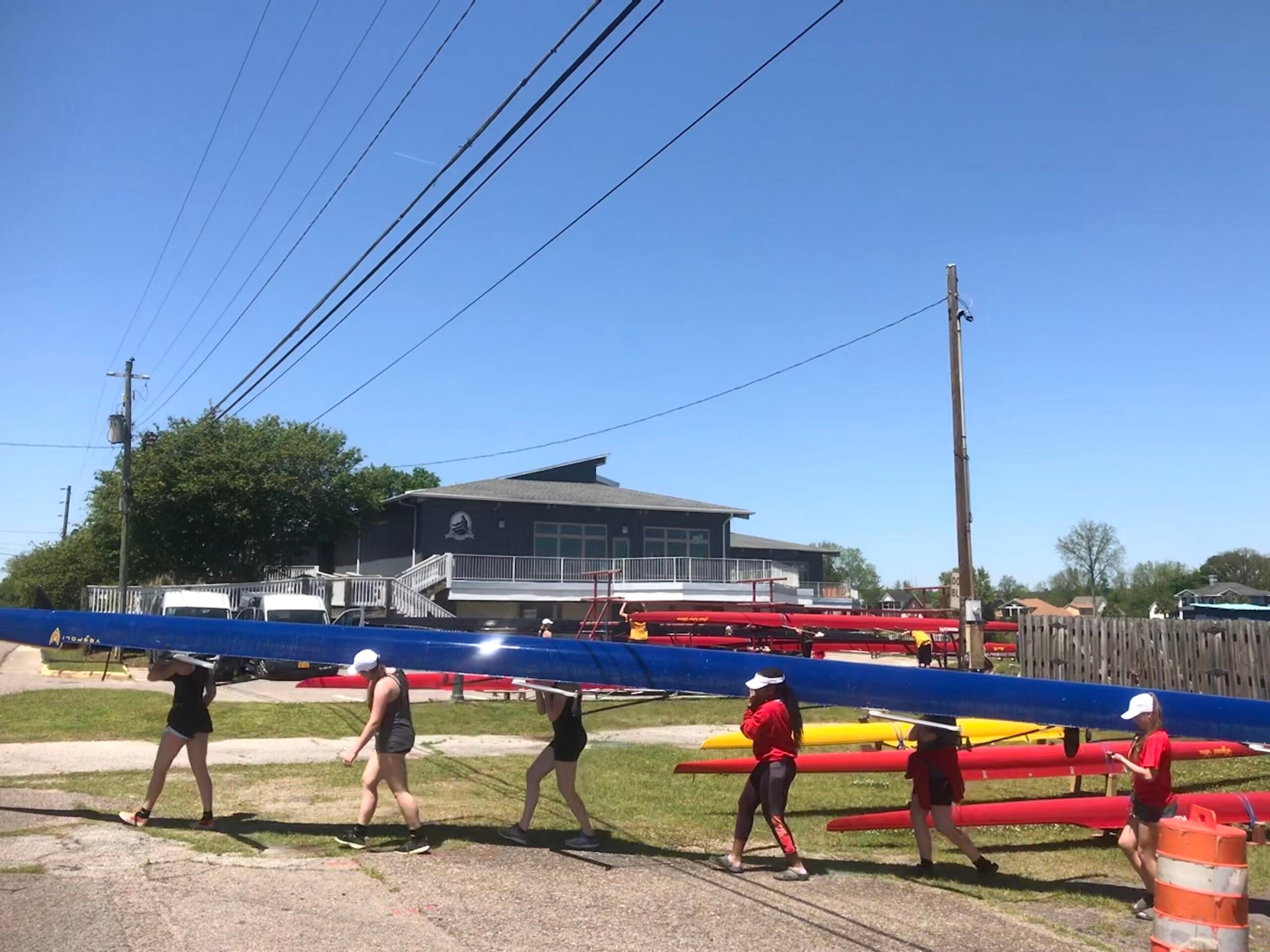 A visiting rowing club transports a scull outside the city-owned Boathouse last April.