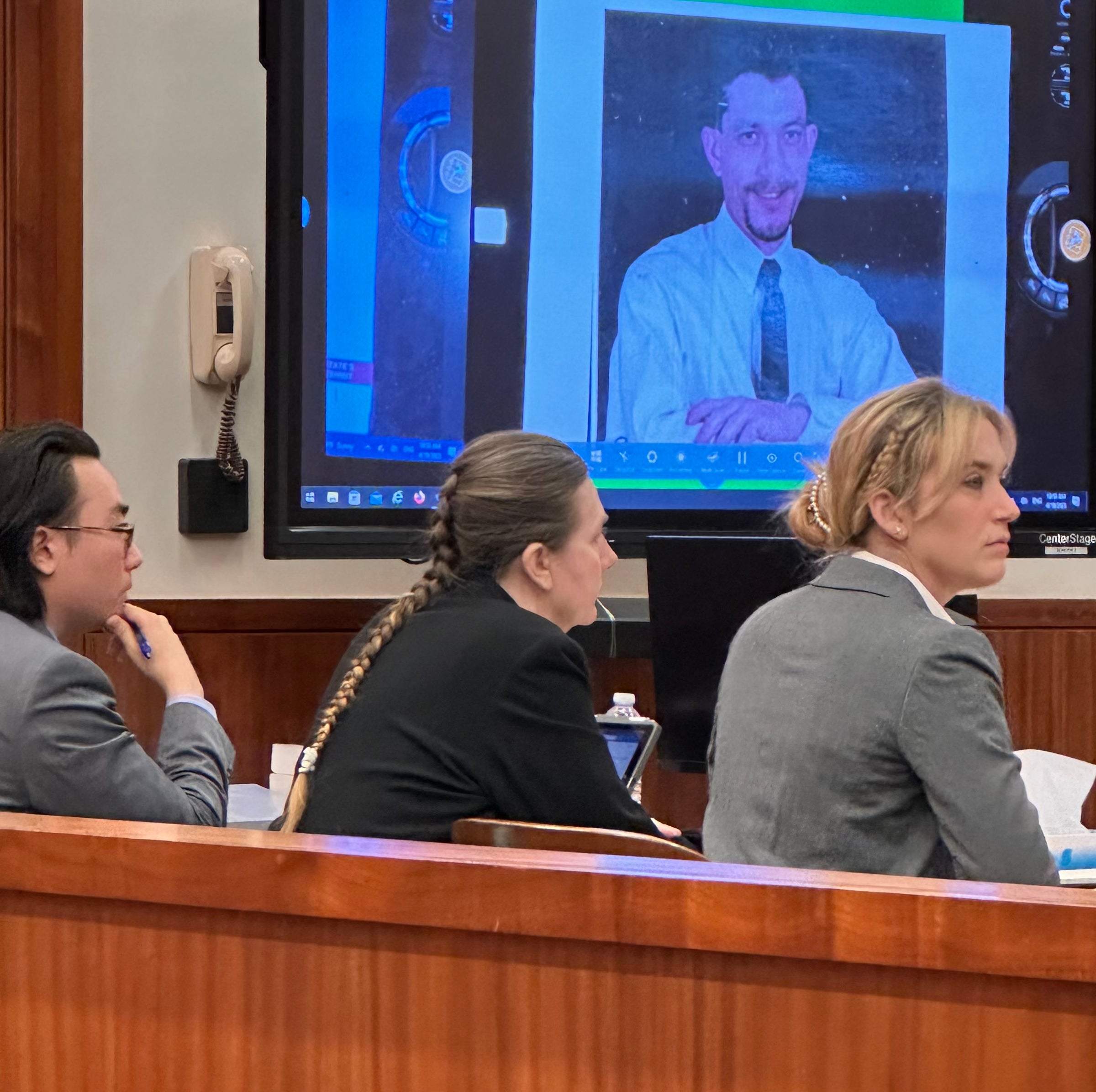 Sandra Dales, center, sits with her attorneys Jay Kim, left, and Jennifer Cross, right. Dales is on trial for murder in the death of her husband, Edward Cruey, whose photo is projected above her. In opening statements Wednesday, Cross portrayed Dales as a victim of domestic violence who killed Cruey in self defense. Staff photo by Susan McCord