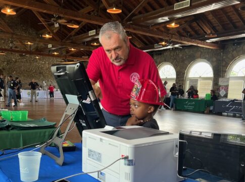 Travis Doss, executive director for Richmond County Board of Elections, shows a future voter how to use an electronic voting machine Saturday at Augusta on Display, a trade-show-style event showcasing local government departments. Photo courtesy board of elections