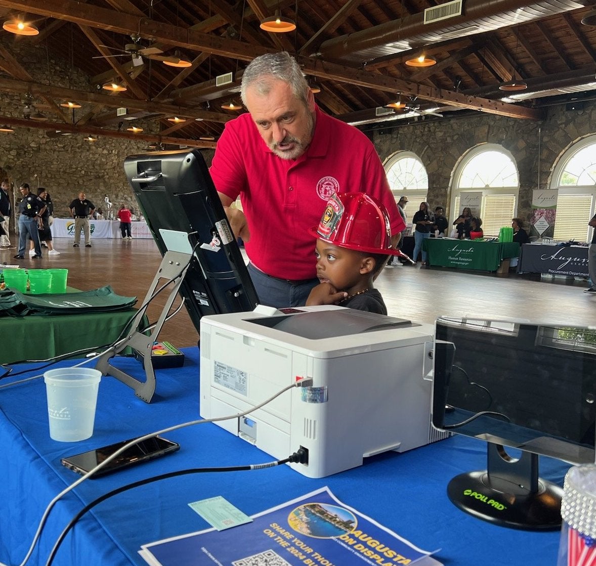 Travis Doss, executive director for Richmond County Board of Elections, shows a future voter how to use an electronic voting machine Saturday at Augusta on Display, a trade-show-style event showcasing local government departments. Photo courtesy board of elections