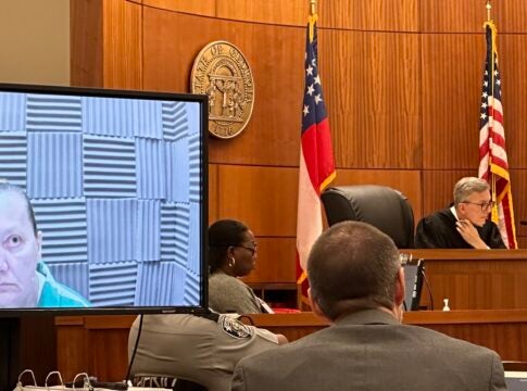 Sandra Dales, left, watches from a monitor at her sentencing Wednesday in Augusta Superior Court. Judge Jesse Stone, at right, sentenced Dales to 20 years in prison for killing her husband and burying his body in their yard. Staff photo by Susan McCord