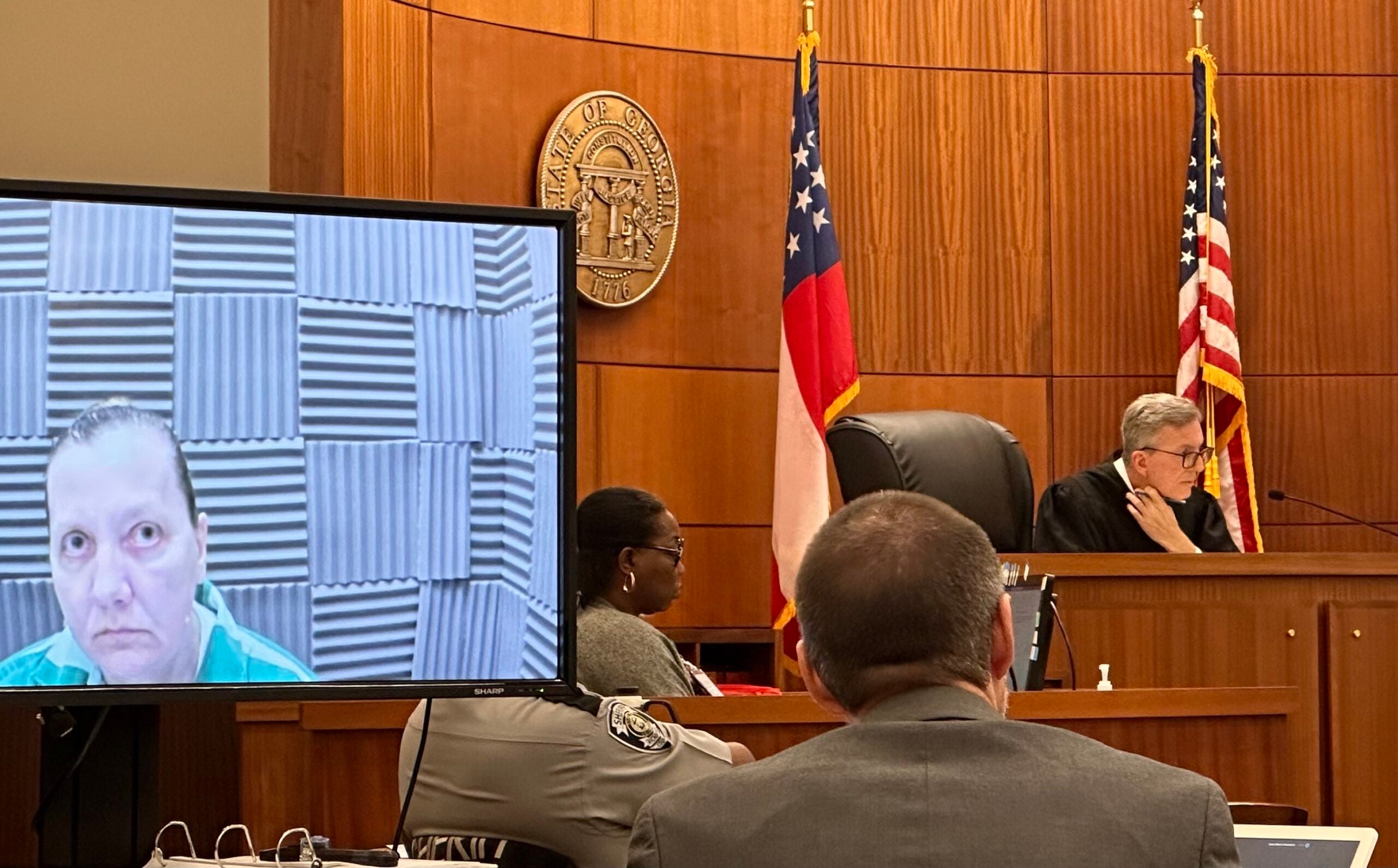 Sandra Dales, left, watches from a monitor at her sentencing Wednesday in Augusta Superior Court. Judge Jesse Stone, at right, sentenced Dales to 20 years in prison for killing her husband and burying his body in their yard. Staff photo by Susan McCord