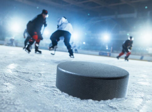 Players from different hockey teams try to get to the puck. Photo courtesy iStockphoto