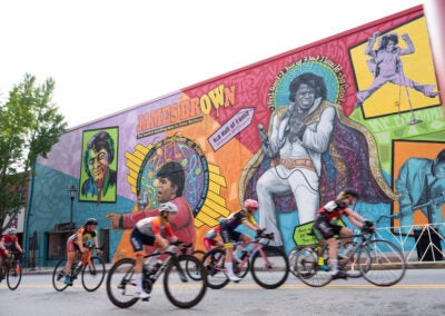 Men Junior 13-14 year old cyclist racing past the James Brown mural in Downtown Augusta.