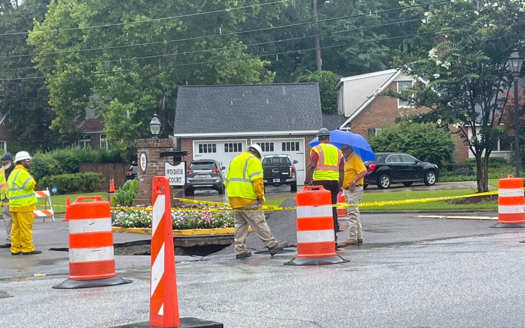 City workers tend to a sinkhole that formed on Walton Way, across the street from Langford Middle School. Staff photo by Skyler Andrews.