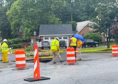 City workers tend to a sinkhole that formed on Walton Way, across the street from Langford Middle School. Staff photo by Skyler Andrews.