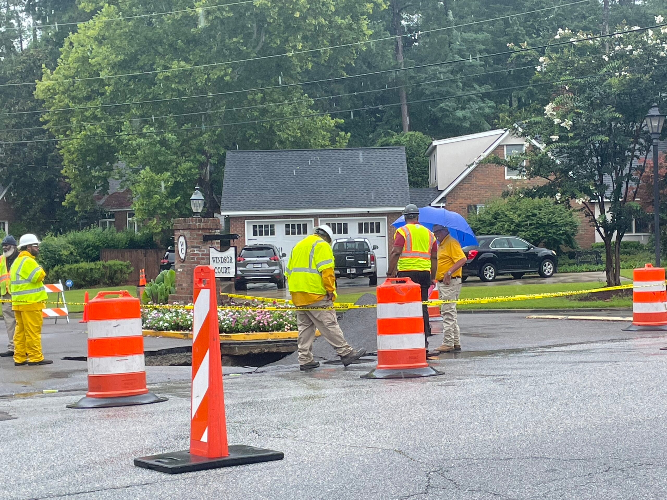 City workers tend to a sinkhole that formed on Walton Way, across the street from Langford Middle School. Staff photo by Skyler Andrews.