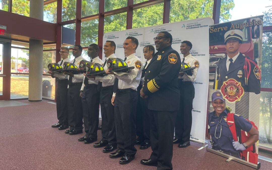 Fire Chief Antonio Burden poses for photos with the 13 new firefighters, of the graduating Recruit Class of 24-03. Photo by Skyler Andrews.