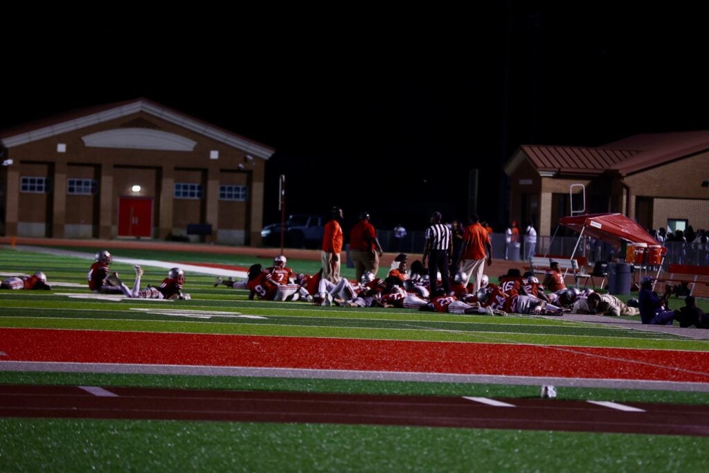Players duck down on the field after shots were fired at the Langley-Westside game on Friday. Photo by Ryan Bacheller