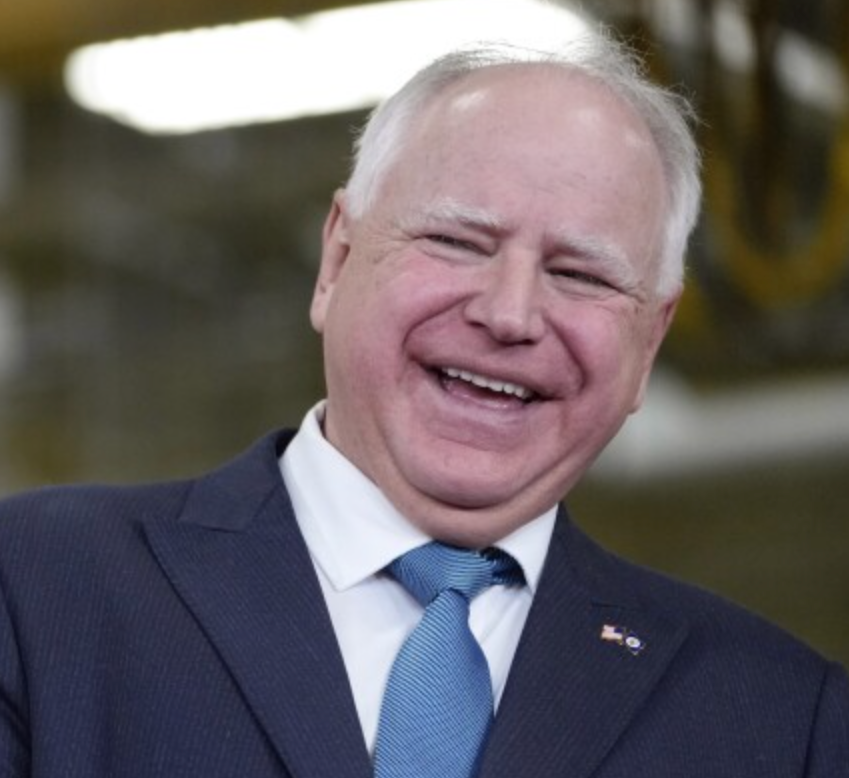 FILE - Minnesota Gov. Tim Walz laughs as he stands with Fridley, Minn., Mayor Scott Lund during a visit to the Cummins Power Generation Facility in Fridley, Minn., Monday, April 3, 2023. (AP Photo/Carolyn Kaster, File)