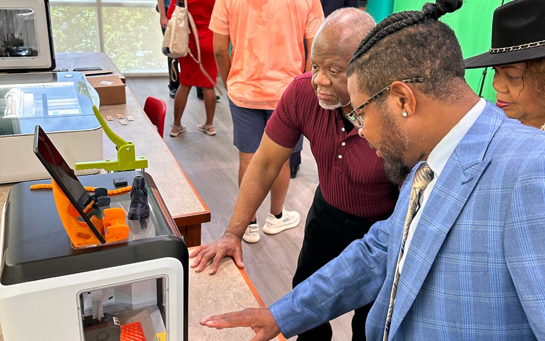 Morris Porter, foreground, chairman of the Augusta-Richmond County Library System board, shows visitors one of the system's new 3D printers. Susan McCord/staff