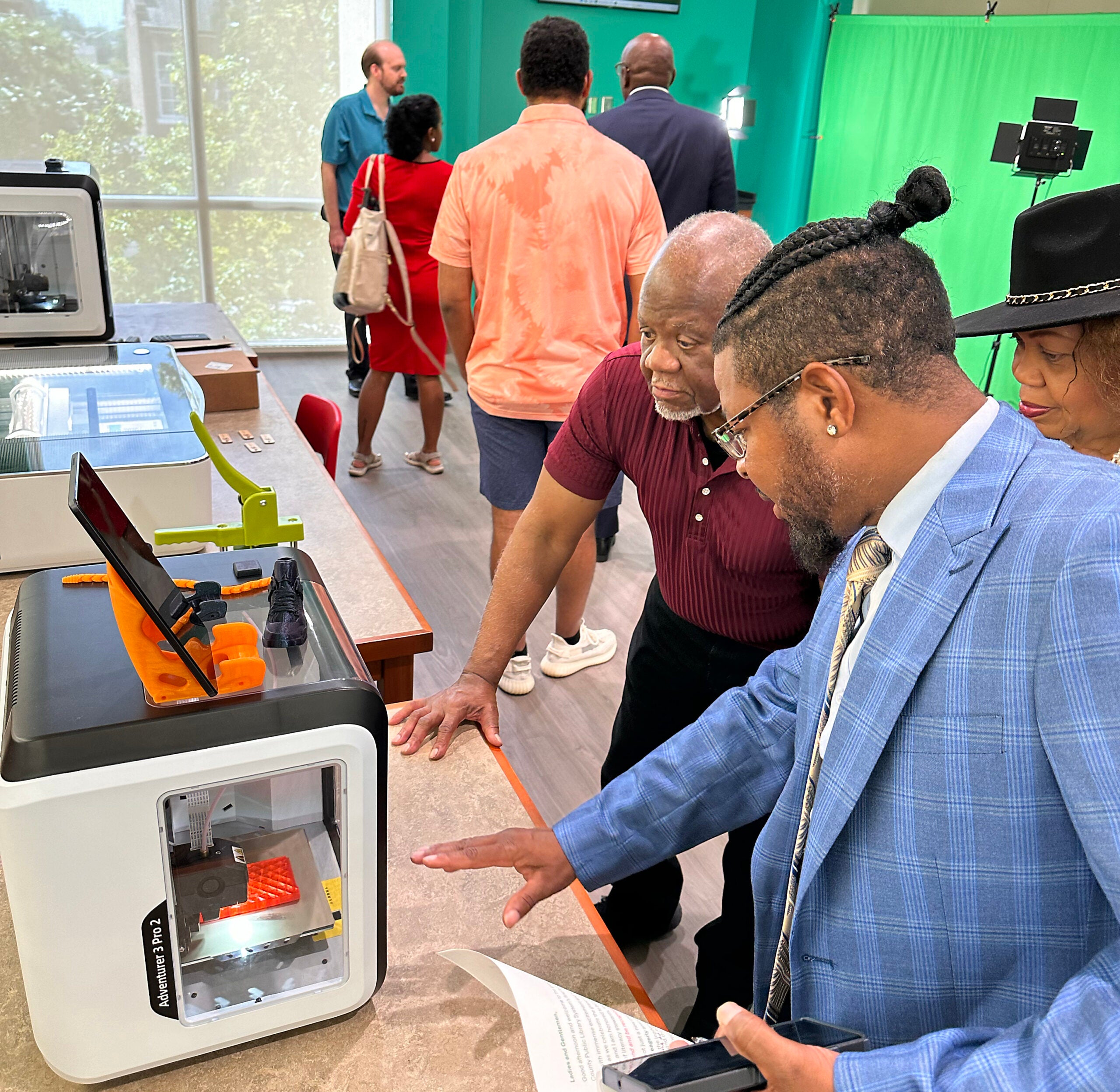 Morris Porter, foreground, chairman of the Augusta-Richmond County Library System board, shows visitors one of the system's new 3D printers. Susan McCord/staff