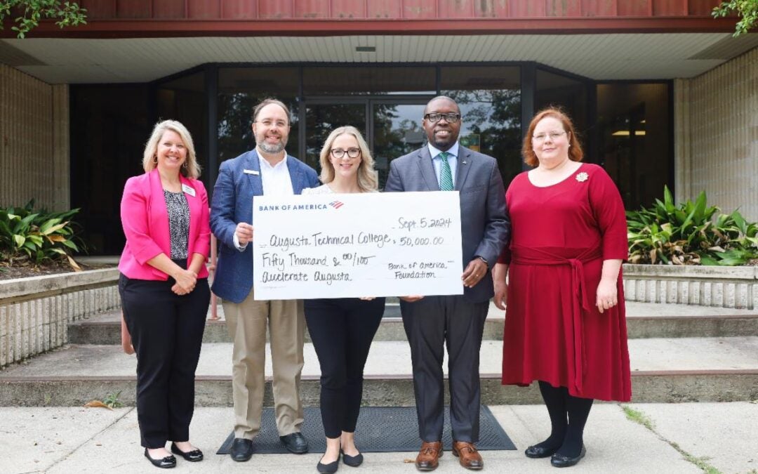 Photo of Augusta Tech holding check