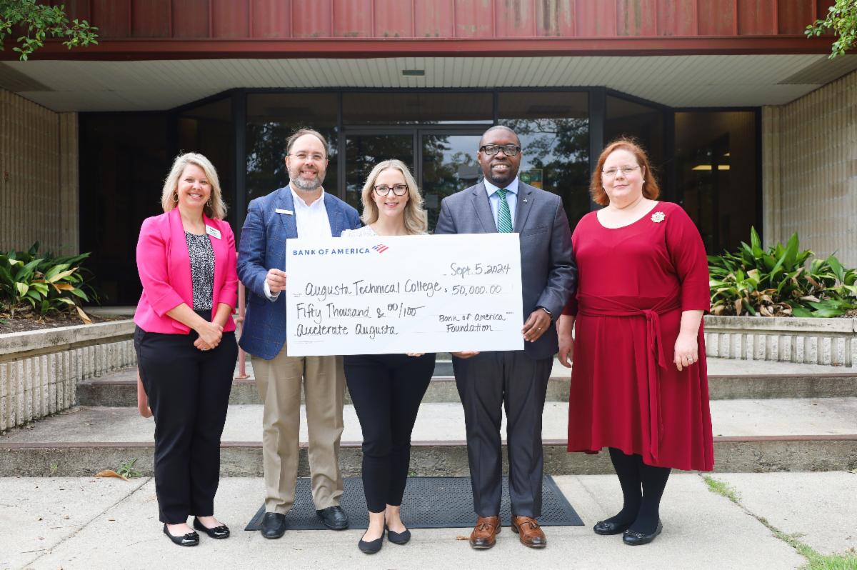 Photo of Augusta Tech holding check