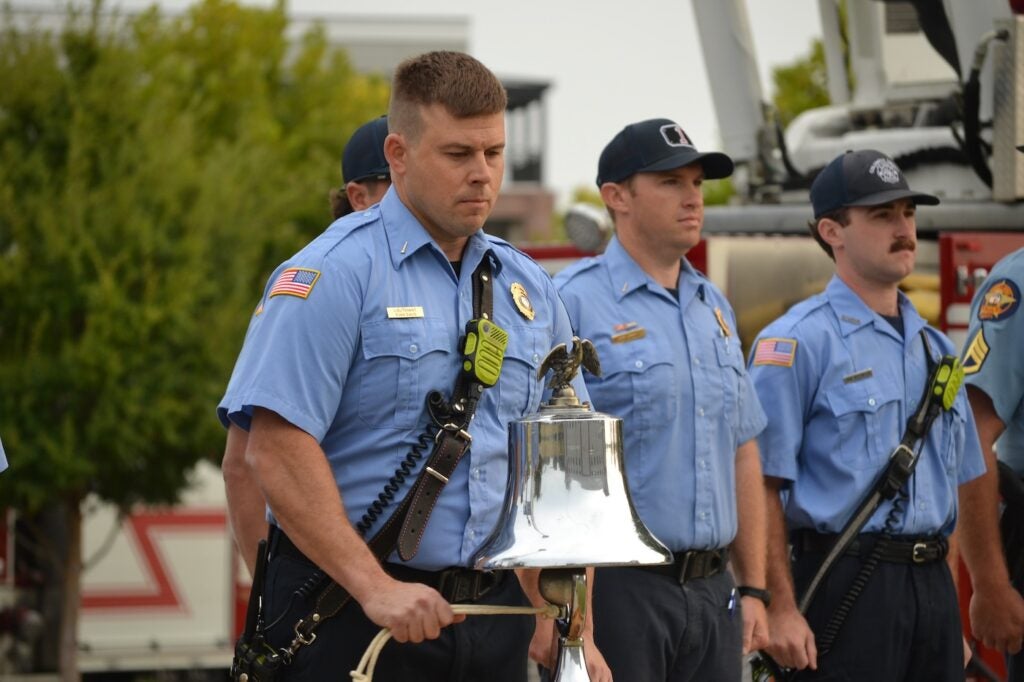 Photo of Lt. Evan Davis ringing a bell