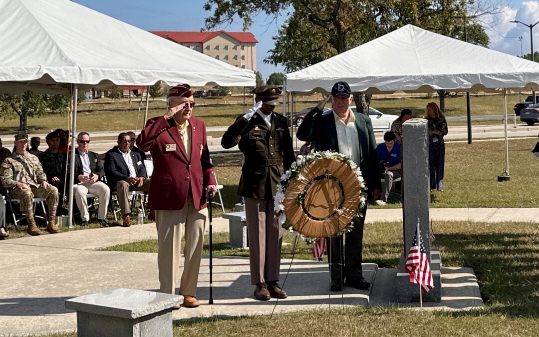 Col. Querin Herlick, left, salutes as a wreath is laid in his honor at Fort Eisenhower's POW/MIA memorial Friday. The American aviator was shot down and held 30 days in captivity by the North Vietnamese in 1969. Staff photo by Susan McCord