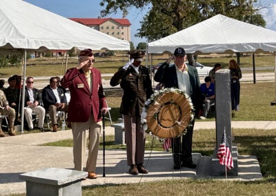 Col. Querin Herlick, left, salutes as a wreath is laid in his honor at Fort Eisenhower's POW/MIA memorial Friday. The American aviator was shot down and held 30 days in captivity by the North Vietnamese in 1969. Staff photo by Susan McCord