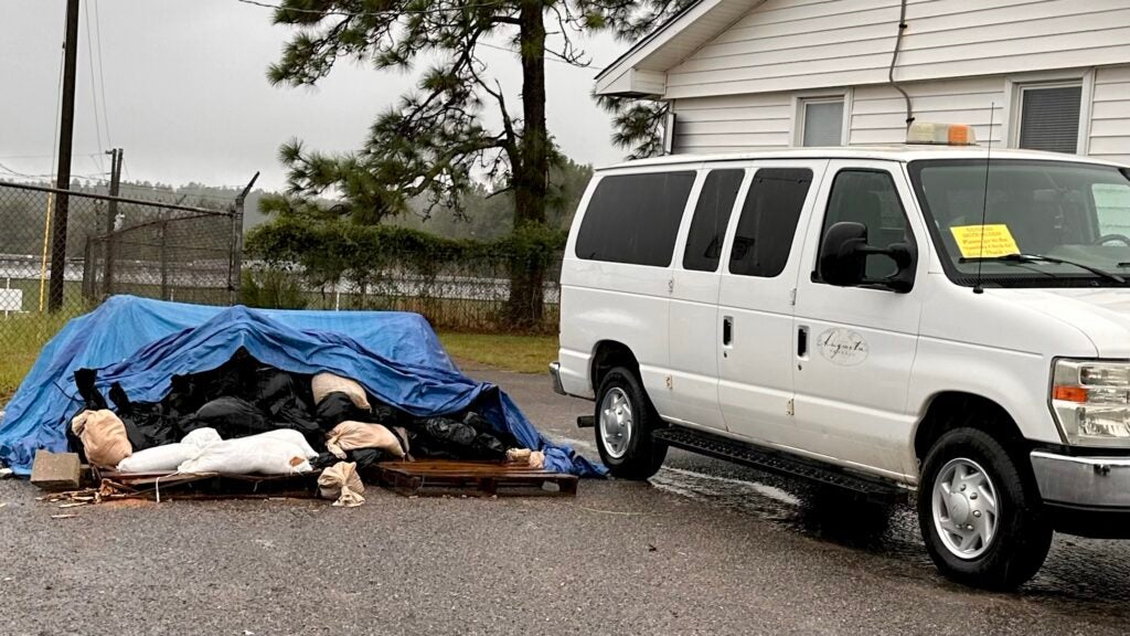 Workers avoid the rain Thursday at Augusta's sandbag distribution site at the city heavy equipment shop on Tobacco Road. Staff photo by Susan Mccord