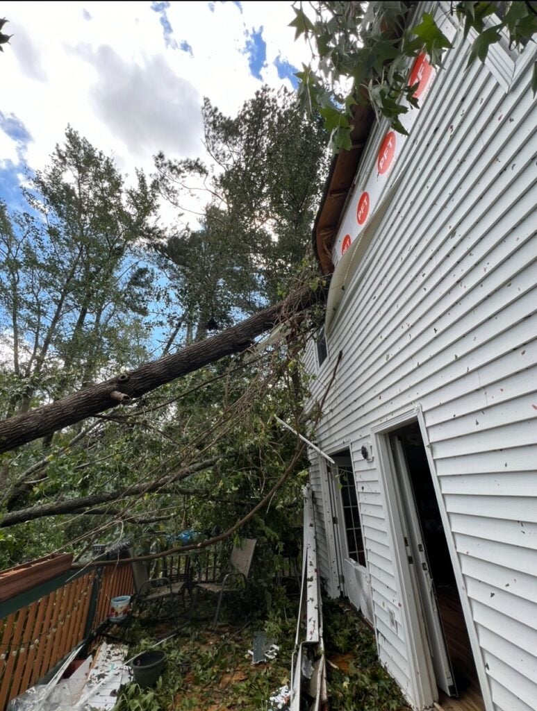 A tree goes through the roof of an Evans house. Staff photo by Susan McCord