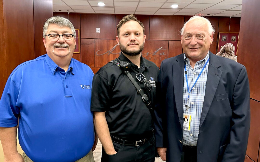 Paramedic Jacob Hansen, center, stands with Central EMS leadership including CEO Gary Coker, right, after being honored for bravery this week before the Augusta Commission. Staff photo by Susan McCord