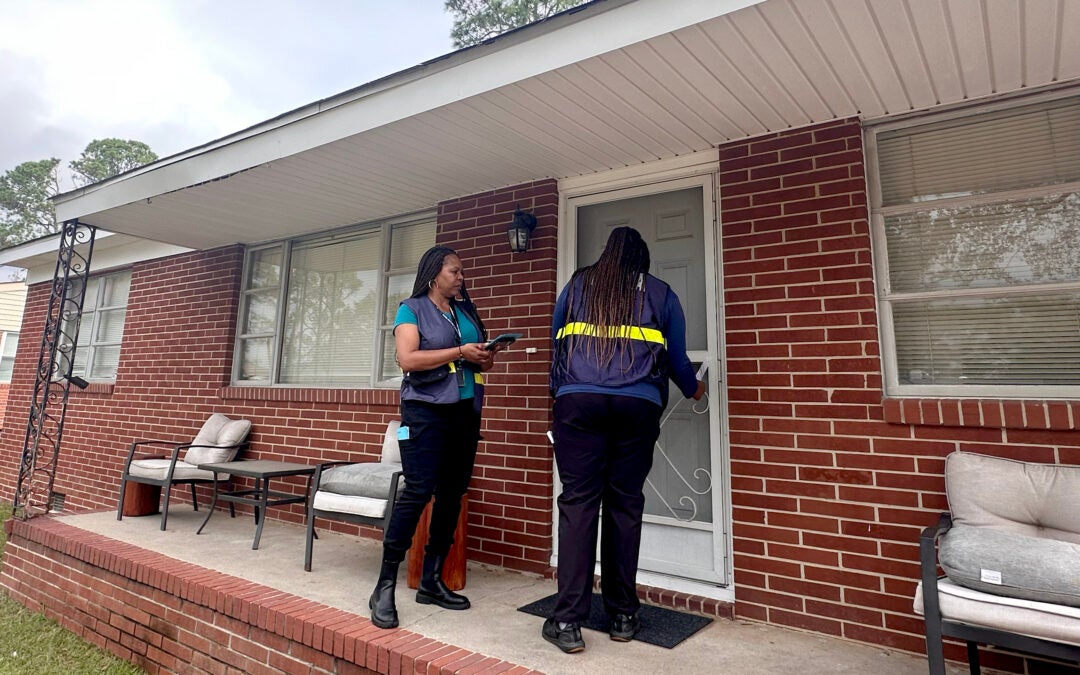 Cristina Whitlow, a reservist with FEMA, and Jalynn Perkins, a FEMA worker knock on doors in an Augusta neighborhood Friday. Staff photo by Susan McCord