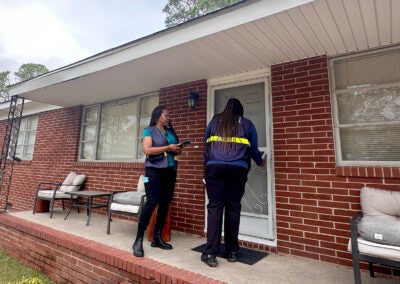 Cristina Whitlow, a reservist with FEMA, and Jalynn Perkins, a FEMA worker knock on doors in an Augusta neighborhood Friday. Staff photo by Susan McCord
