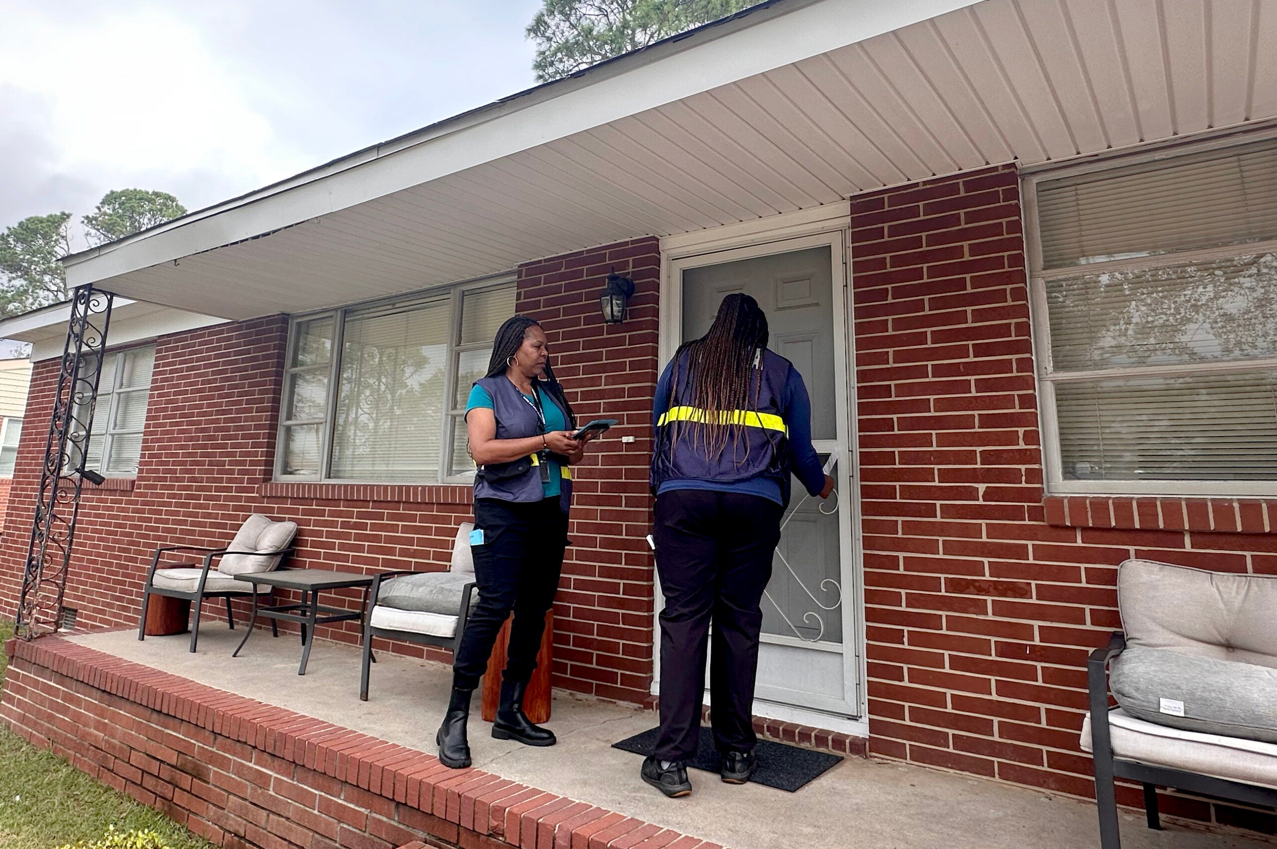 Cristina Whitlow, a reservist with FEMA, and Jalynn Perkins, a FEMA worker knock on doors in an Augusta neighborhood Friday. Staff photo by Susan McCord