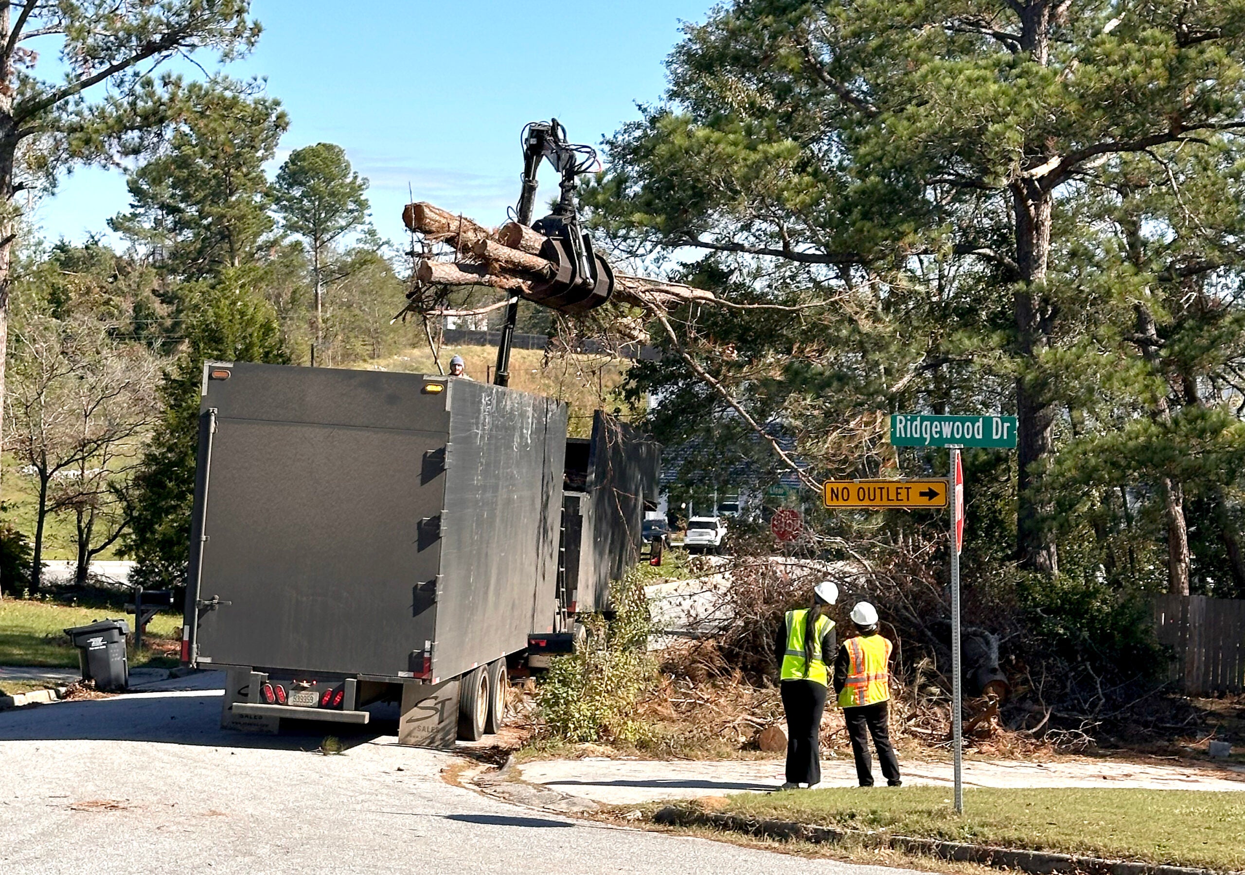 A debris truck removes trees from Sandy Ridge Place near the Columbia-RIchmond county line Wednesday. Staff photo by Susan McCord