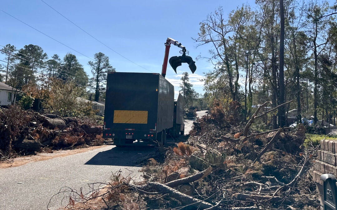 A debris truck removes debris from Poindexter Drive in Augusta. Staff photo by Susan McCord
