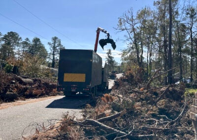 A debris truck removes debris from Poindexter Drive in Augusta. Staff photo by Susan McCord