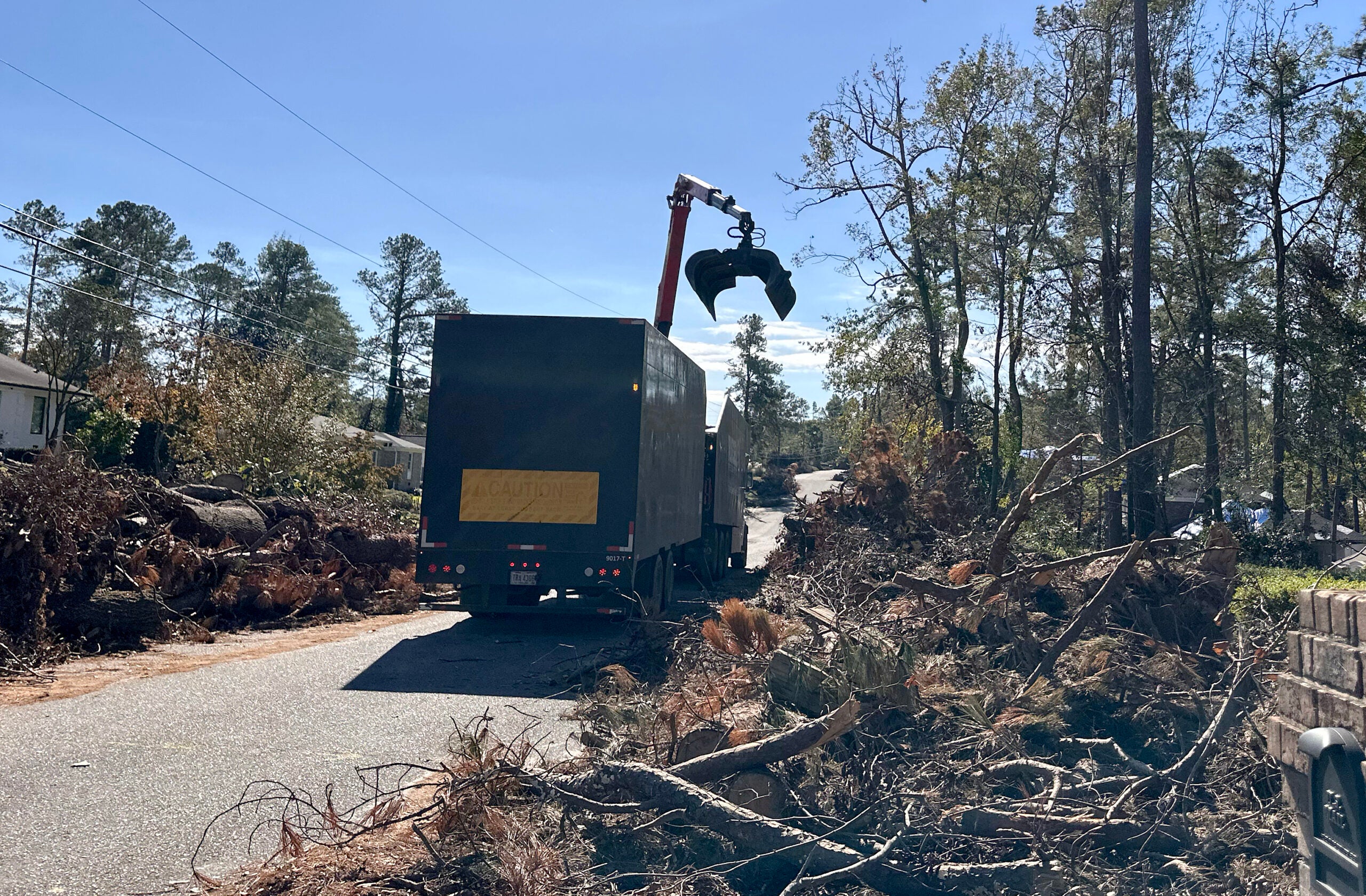 A debris truck removes debris from Poindexter Drive in Augusta. Staff photo by Susan McCord