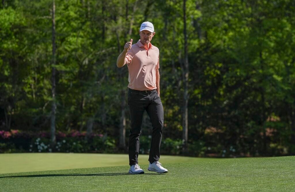 Justin Rose of England waves to patrons as he walks to the No. 12 tee during the final round of the Masters at Augusta National Golf Club, Sunday, April 13, 2025.