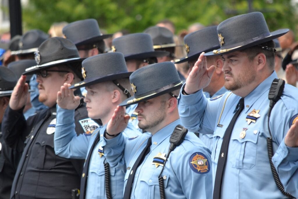 Law enforcement officers salute the body of Deputy Brandon Sikes. Staff photo by Stephanie Hill