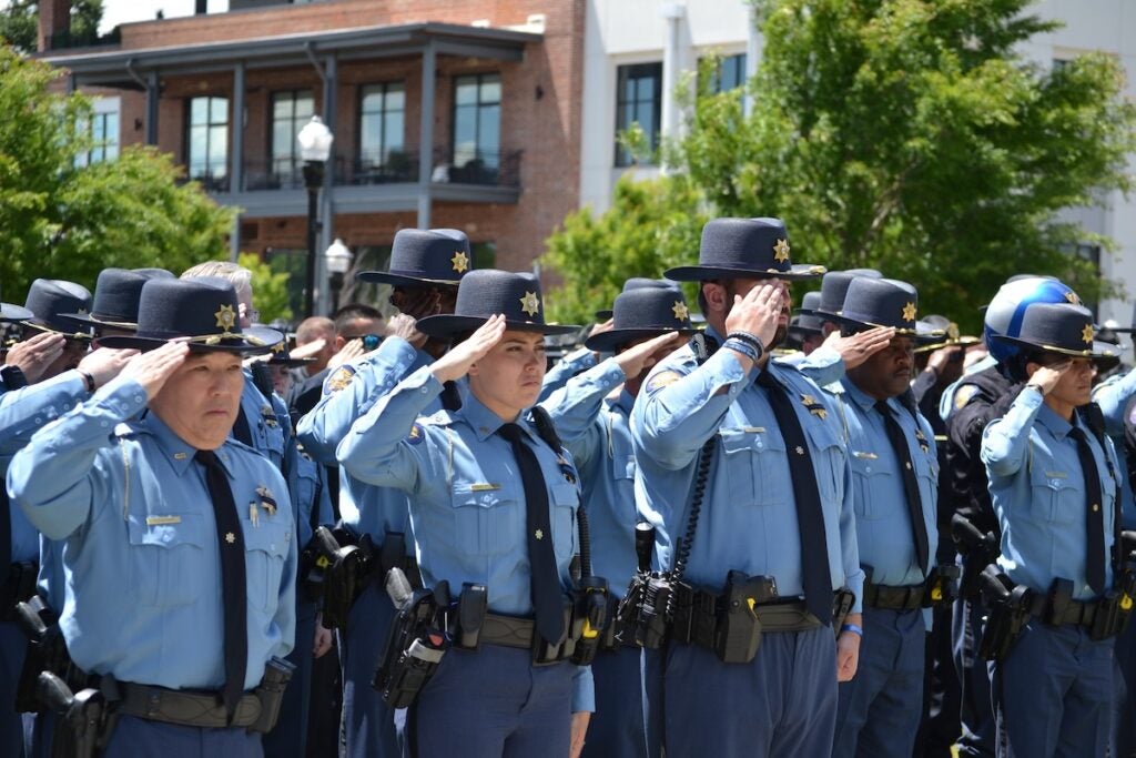 Deputies salute ahead of the 21-gun salute at the funeral of Deputy Brandon Sikes on Monday, May 5. Staff photo by Stephanie Hill