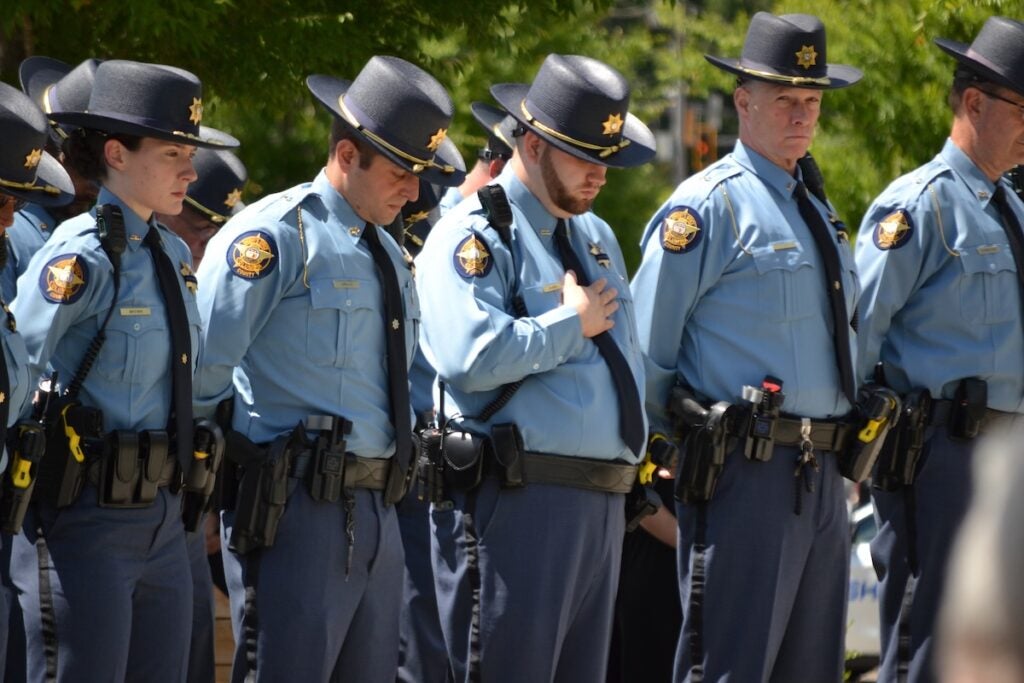 Deputies bow their heads during a prayer at the funeral for Deputy Brandon Sikes. Staff photo by Stephanie Hill