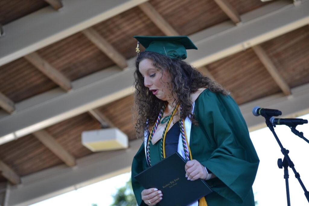 Katie Grace Daley looks on as the piece of paper in her diploma falls on the ground at the Greenbrier High School graduation. Staff photo by Stephanie Hill