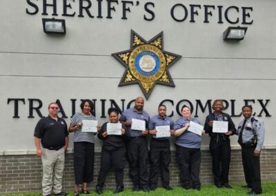 Pictured (left to right): Sergeant Michael Trap, followed by graduates Detra Willis, Gloria Chin, Terrell Mack, Isiah Williams, Michelle Johnson, Jasmine Donahoo, and Captain Kenneth Daniels offering congratulations. Photo courtesy Richmond County Sheriff's Office.