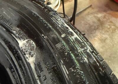 A tire shows sidewall damage from a curb strike, showing bubbles where air is leaking. Photo by Taylor Bryant