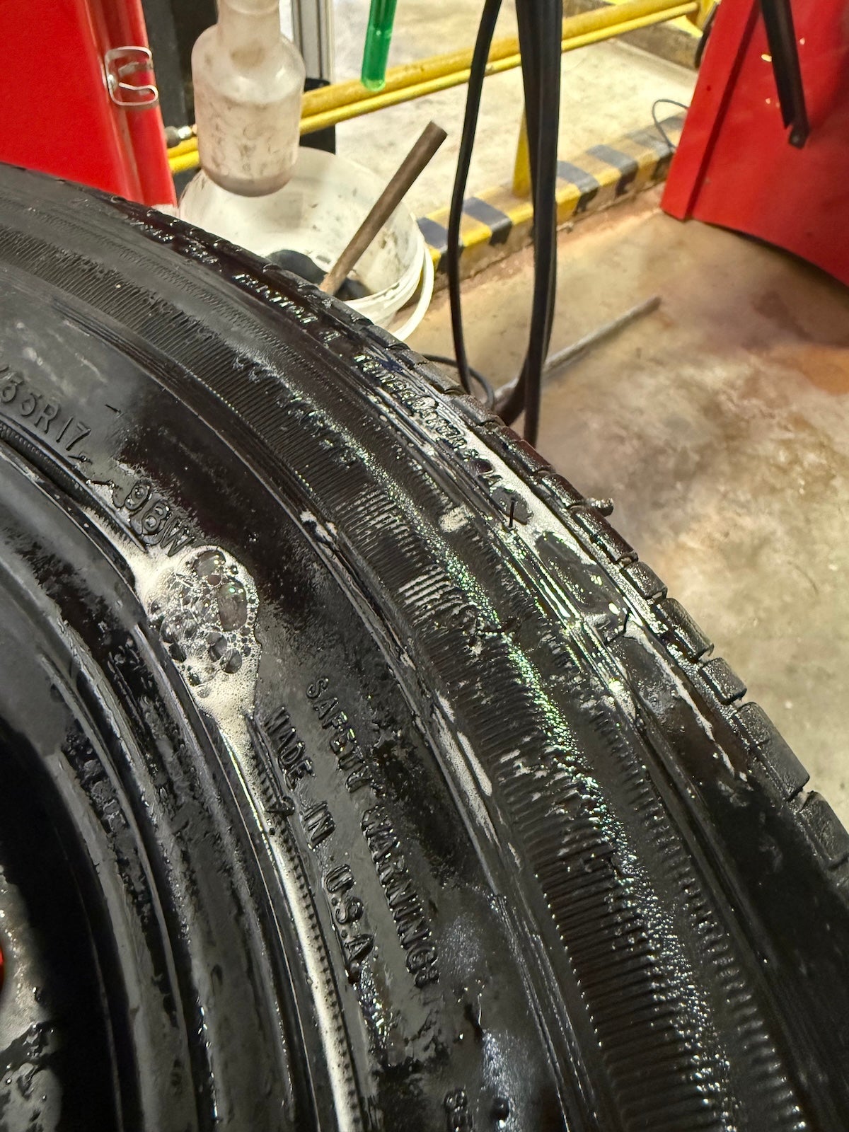 A tire shows sidewall damage from a curb strike, showing bubbles where air is leaking. Photo by Taylor Bryant