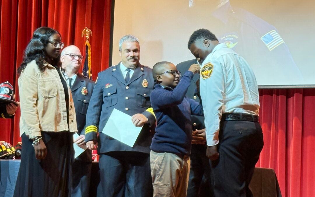Wesley Brinson pinned by his son at the firefighter graduation ceremony. Photo by Drew Wall