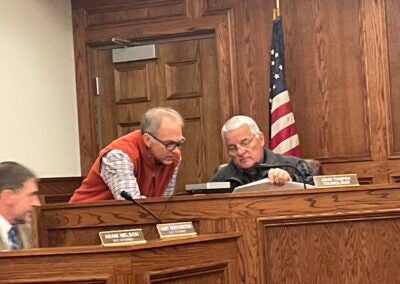 Photo of two men talking at the Harlem City Council meeting on Monday, Oct. 27.