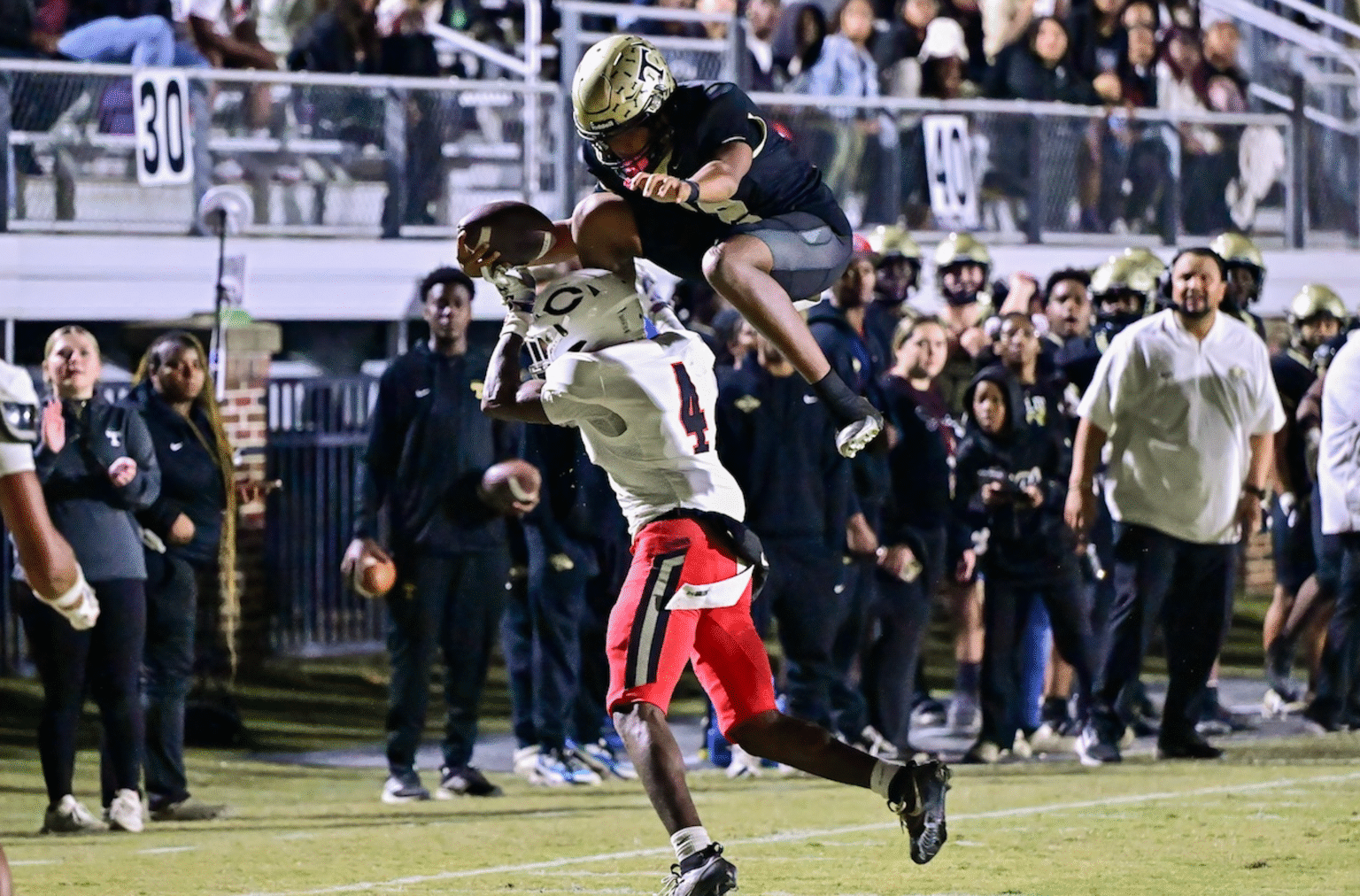 Thomson quarterback Markevion Jones (12) leaps over a Callaway defender during a GHSA Region 2A second round playoff game in Thomson, Ga., on Friday, November 21, 2025. (photo by Rob Davis)
