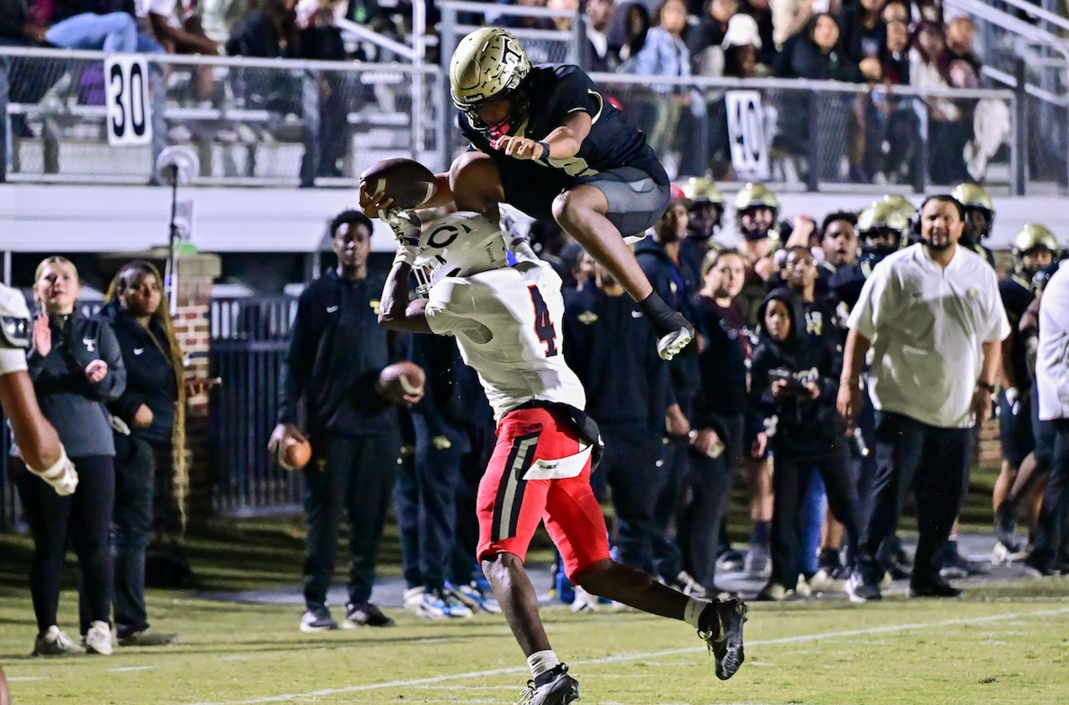 Thomson quarterback Markevion Jones (12) leaps over a Callaway defender during a GHSA Region 2A second round playoff game in Thomson, Ga., on Friday, November 21, 2025. (photo by Rob Davis)
